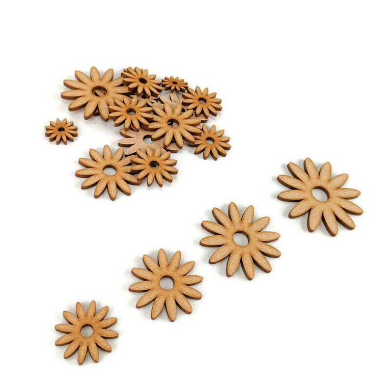 May include: A collection of wooden flower shapes in various sizes, all with a natural wood color. The flowers are arranged in a cluster and scattered across a white background.
