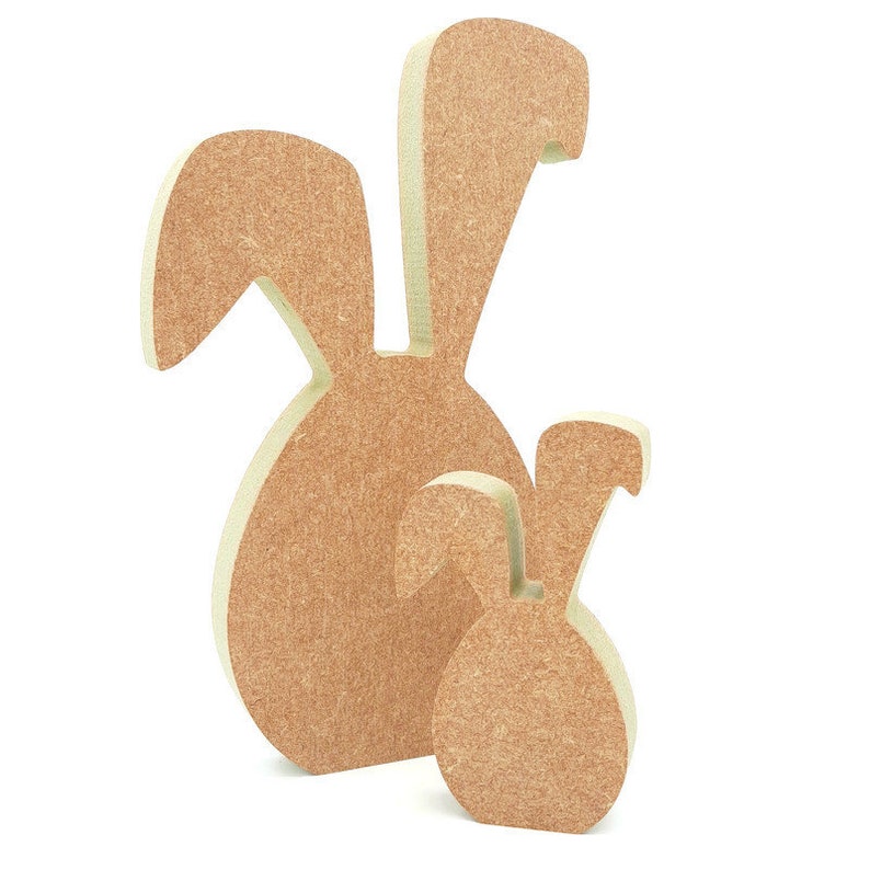 May include: Two wooden bunny shapes, one larger than the other, both with a light brown color and a textured surface.