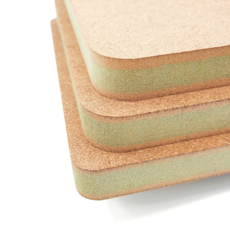May include: Two square pieces of wood with a green edge. The wood is a light brown color and has a rough texture.