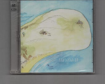 Può includere: Un'immagine di un CD con una mappa disegnata a mano di un'isola, una spiaggia e un oceano. L'opera d'arte è nei toni del blu, giallo e marrone, con il testo "A.S.S.O. NO PLAN LIVE VOLUME 2". La custodia ha un'etichetta "2 CD".
