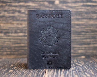 Könnte beinhalten: Schwarzer Leder-Reisepass-Etui mit den geprägten Worten "PASSPORT" und "United States of America" auf der Vorderseite.