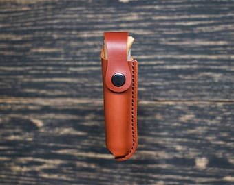 手作りのレザーベルト鞘で、オピネルNo8をスタイリッシュに保護しましょう。植物タンニンなめしのレザーと安全なボタン留めで作られています。
