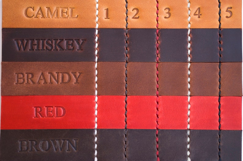 Op de afbeelding: Lederstalen in vijf verschillende kleuren: camel, whisky, brandy, rood en bruin. Elke kleur is gelabeld met een nummer van 1 tot 5.