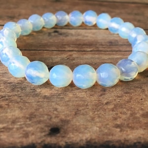 May include: A bracelet made of white opal beads. The beads are round and have a smooth, polished finish.