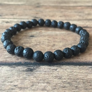 May include: A black beaded bracelet made of lava rock.