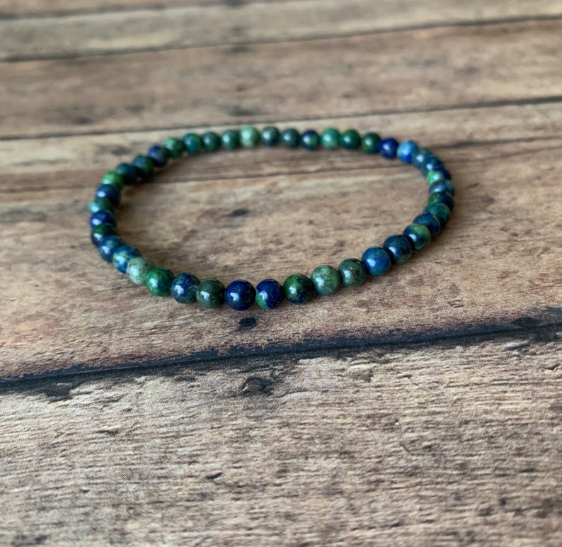 May include: A blue and green gemstone bracelet with small round beads.