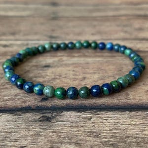 May include: A blue and green gemstone bracelet with small round beads.