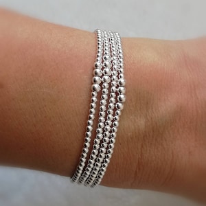 May include: A silver bracelet made of multiple strands of small beads.
