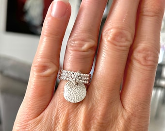 Three-row ring in 925 silver with a curved and hammered medallion