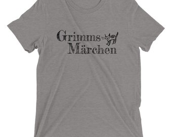 Może przedstawiać: Szary t-shirt z nadrukiem "Grimms Märchen" i czarnym kotem.