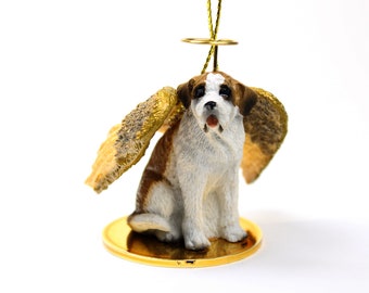 Könnte beinhalten: Eine braune und weiße Saint-Bernhard-Hundefigur mit goldenen Flügeln und einem Heiligenschein, die auf einem goldenen Sockel sitzt. Die Figur ist ein Weihnachtsornament.