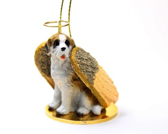 May include: A small, white, brown, and black dog figurine with a gold halo and wings. The figurine is sitting on a gold base.