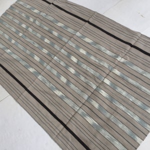 May include: A gray and white striped fabric with black stripes running along the edges. The fabric has a subtle ikat pattern.