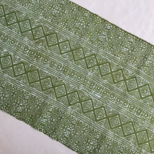 Pu&ograve; includere: Tessuto verde con un motivo geometrico bianco. Il motivo &egrave; composto da quadrati, rombi e altre forme.