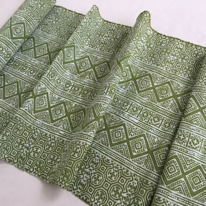 Pu&ograve; includere: Tessuto verde con un motivo geometrico bianco. Il motivo &egrave; composto da quadrati e rombi ripetuti.