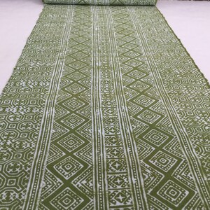 Pu&ograve; includere: Tessuto verde con un motivo geometrico bianco. Il motivo &egrave; composto da rombi, quadrati e stelle ripetuti.