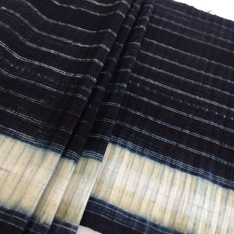 May include: Striped fabric in shades of blue and white. The fabric has a textured, woven look and is folded in half.