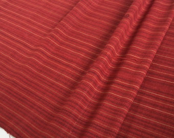 Peut inclure: Tissu rayé rouge avec un léger brillant. Le tissu est tissé avec de fines rayures horizontales dans une nuance de rouge plus claire.