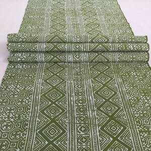 Pu&ograve; includere: Tessuto verde e bianco con un motivo geometrico. Il tessuto &egrave; piegato in tre parti e ha uno sfondo bianco con un motivo geometrico verde.