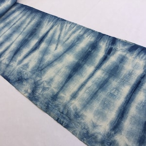 May include: A long strip of fabric with a blue and white tie-dye pattern. The fabric is folded in half and the edges are visible.
