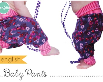 Puede incluir: Un pantalón para bebé con estampado floral en tonos morados, rosas y blancos. El pantalón tiene una cintura y puños a rayas rosas y blancas. El pantalón se muestra en un modelo de bebé.