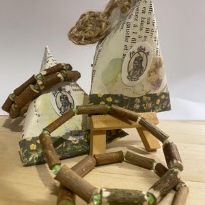 May include: Two wooden bracelets with green beads. The bracelets are made of natural wood and have a rustic look. The bracelets are displayed on a small wooden easel.