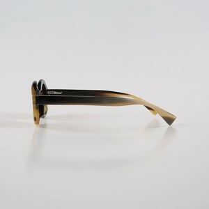 May include: A pair of tortoiseshell sunglasses with a dark brown frame and light brown temples.