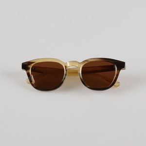 May include: Brown and beige tortoiseshell sunglasses with brown lenses.