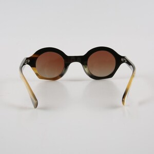 May include: A pair of round, tortoiseshell sunglasses with brown gradient lenses.