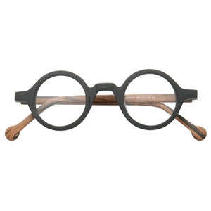 Pu&ograve; includere: Occhiali rotondi neri con aste in legno marrone. Le aste sono contrassegnate con "K9240 35D27-145 C2".
