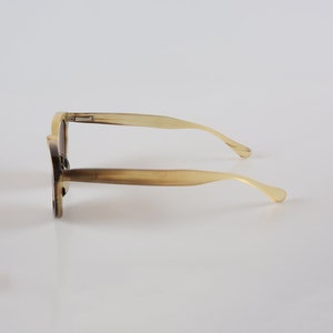 May include: A pair of tortoiseshell sunglasses with a brown frame and brown lenses.