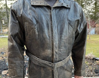 May include: A brown leather jacket with a belt and a zipper closure. The jacket has a stand-up collar and a distressed look.