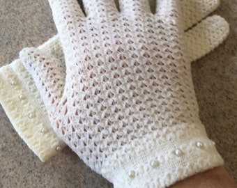 May include: A pair of white crocheted gloves with pearl embellishments on the cuffs.