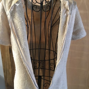 Puede incluir: Un vestido de lino beige con una cremallera en la espalda. El vestido est&aacute; en un maniqu&iacute;.