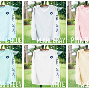May include: Six long-sleeve shirts in various colors: Arctic Blue, Pearl Gray, Pink Blossom, Seagrass Green, White, and Pale Yellow. Each shirt has a logo on the chest and the words "CONCH DISTRICT" printed on the sleeve.