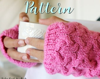 May include: Pink knitted fingerless gloves with a cable knit pattern. The gloves are being worn by a person holding a white mug. The text "Pattern" is written in blue above the gloves.