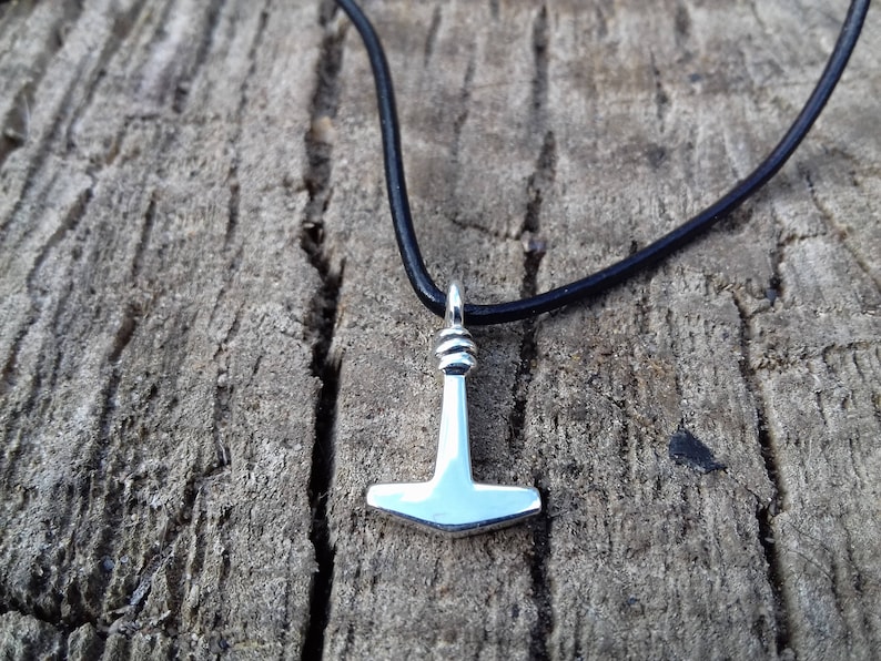 Op de afbeelding: Een zilveren Mjolnir-hangerketting aan een zwart leren koord. De hanger is een replica van Thors hamer uit de Noorse mythologie.