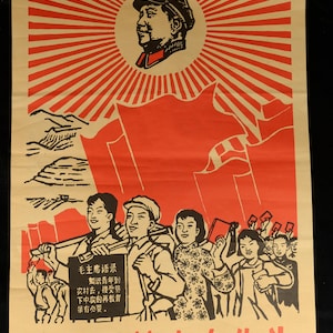 May include: Vintage Chinese propaganda poster in red and beige. The poster features a portrait of a man with a star on his hat, surrounded by a sunburst design. Below, a group of people march with flags. Text in Chinese is included.