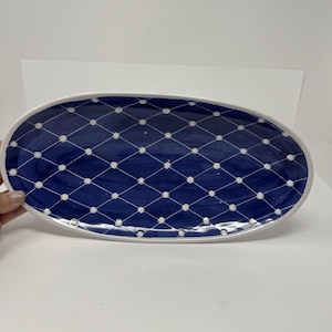 Puede incluir: Plato ovalado para servir con fondo azul marino y un patrón de diamantes blancos. El plato tiene un borde blanco. El diseño es simple y elegante, adecuado para servir alimentos. Ideal para diversas ocasiones.