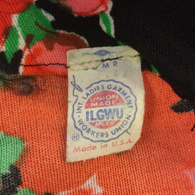 May include: A white tag with blue lettering that reads "Int. Ladies Garment Workers Union Made ILGWU AFL-CIO Union Made in U.S.A."