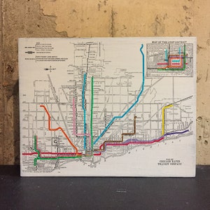 May include: A vintage map of the Chicago Rapid Transit Company, showing the Loop District and surrounding areas. The map features a detailed network of train lines in various colors, including red, blue, green, orange, and purple. The map also includes text labels for streets, stations, and points of interest.