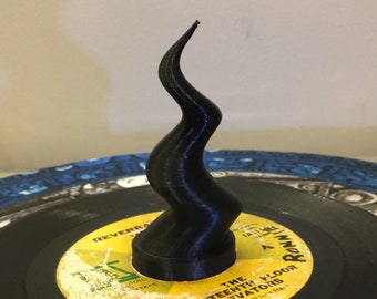 Könnte beinhalten: Eine schwarze, 3D-gedruckte Spiralskulptur sitzt auf einem schwarzen Vinyl-Schallplatten. Das Plattenlabel ist gelb und trägt den Text "The Thirteenth Floor Elevators" und "Reverberation (Live)".