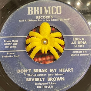 K&ouml;nnte beinhalten: Eine Vintage-Schallplatte mit 45 U/min von Beverly Brown mit dem Titel "Don't Break My Heart". Das Plattenlabel ist blau mit wei&szlig;em Text und zeigt eine gelbe Plastikspinne in der Mitte. Das Label enth&auml;lt auch den Namen des Plattenlabels "Brimco Records" und die Adresse "5223 N. Claiborne Ave. - New Orleans, La. 70117".