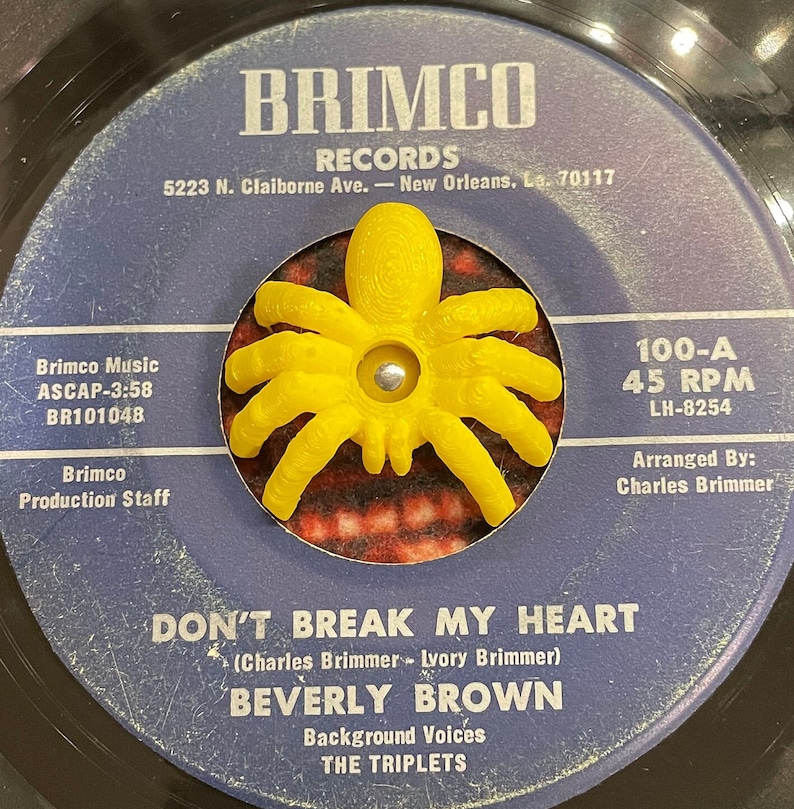 K&ouml;nnte beinhalten: Eine Vintage-Schallplatte mit 45 U/min von Beverly Brown mit dem Titel "Don't Break My Heart". Das Plattenlabel ist blau mit wei&szlig;em Text und zeigt eine gelbe Plastikspinne in der Mitte. Das Label enth&auml;lt auch den Namen des Plattenlabels "Brimco Records" und die Adresse "5223 N. Claiborne Ave. - New Orleans, La. 70117".