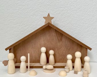 May include: A wooden nativity set with a brown wooden stable, a star on top, and wooden figures of Mary, Joseph, baby Jesus, and the three wise men. The set also includes a wooden manger, a wooden donkey, a wooden sheep, and a wooden star.