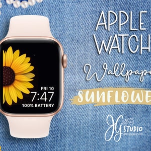 May include: A pink Apple Watch with a black face displaying a sunflower image and the time 7:47. The watch face also shows "FRI 10" and "100% BATTERY". The watch is on a blue denim background with the text "APPLE WATCH Wallpaper SUNFLOWER" above it.