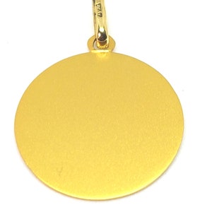 Puede incluir: Un colgante dorado con un dise&ntilde;o circular. El colgante tiene una superficie texturizada y un peque&ntilde;o lazo en la parte superior para una cadena. El lazo tiene marcas. El colgante est&aacute; sobre un fondo blanco.