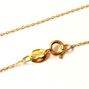 May include: A gold chain necklace with a lobster clasp closure. The clasp is marked "14K" and "585".