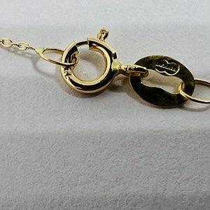 May include: Close-up of a gold chain necklace clasp with a small oval tag that says "925 Italy".