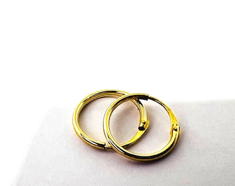Può includere: Un paio di orecchini a cerchio dorati. Gli orecchini sono semplici ed eleganti e sarebbero un ottimo regalo per ogni occasione.